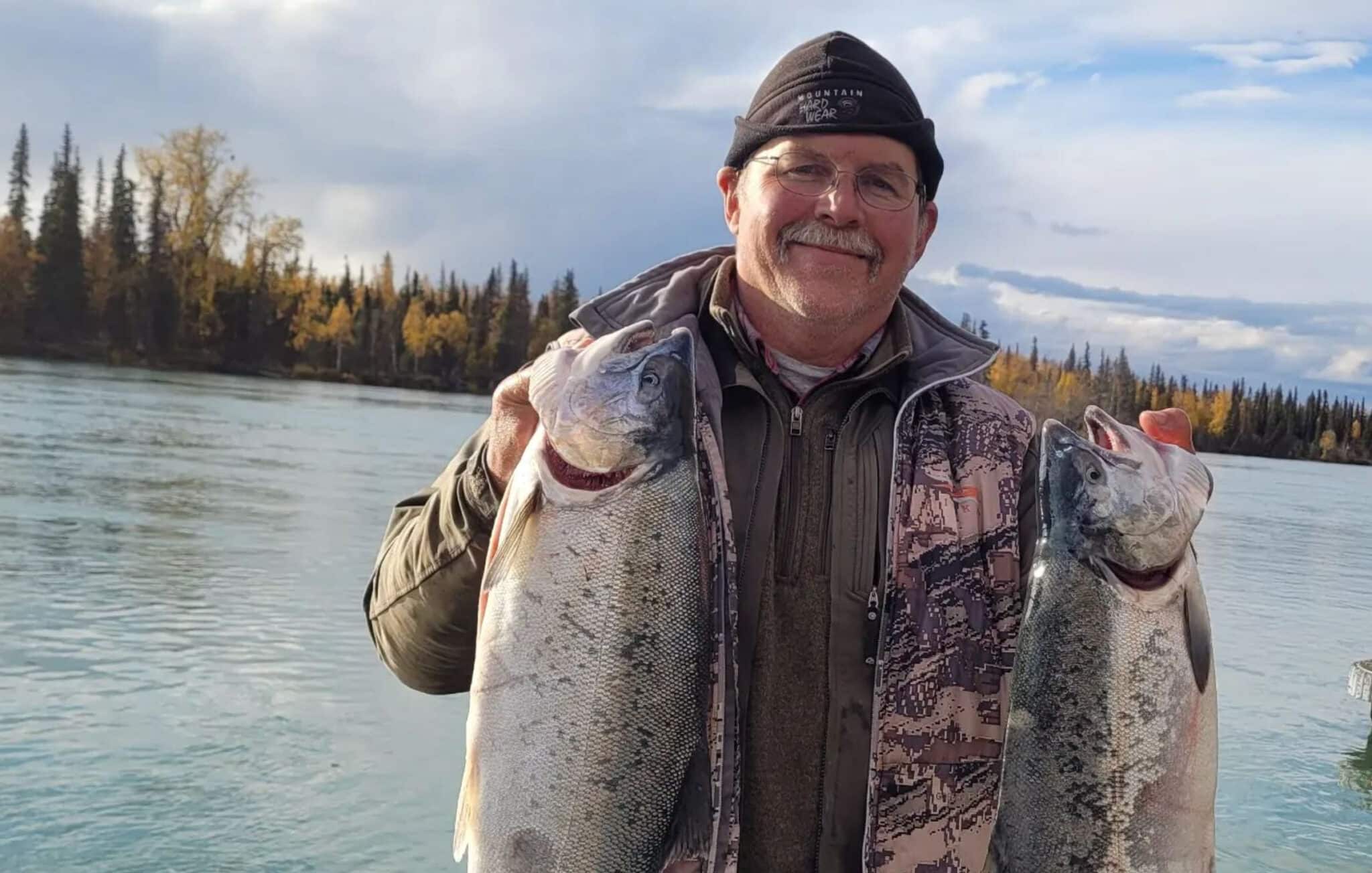 fisherman holding two salmon