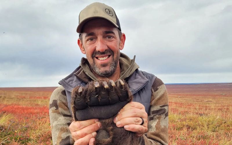 hunter holding bear paw