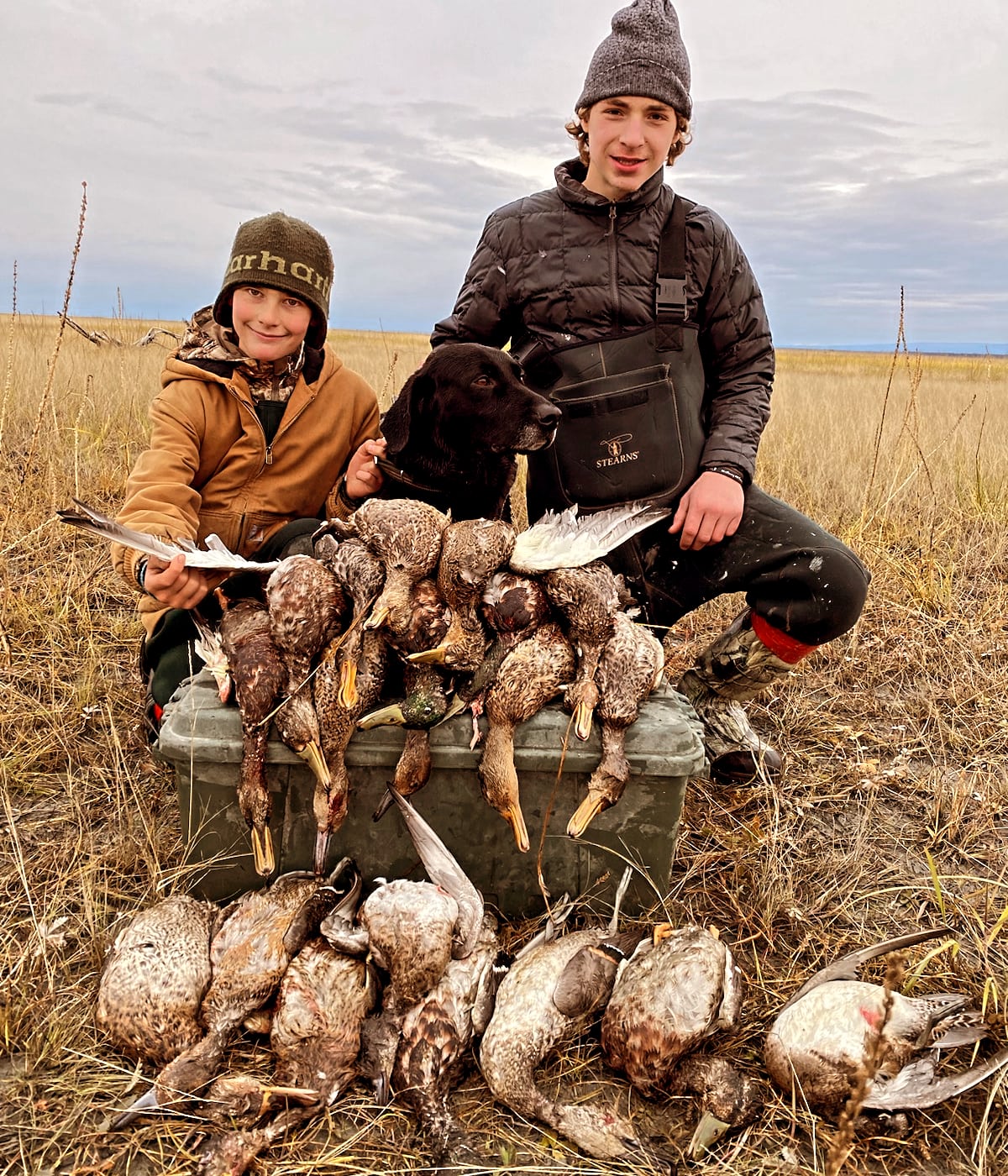 two boys with waterfowl after their hunt